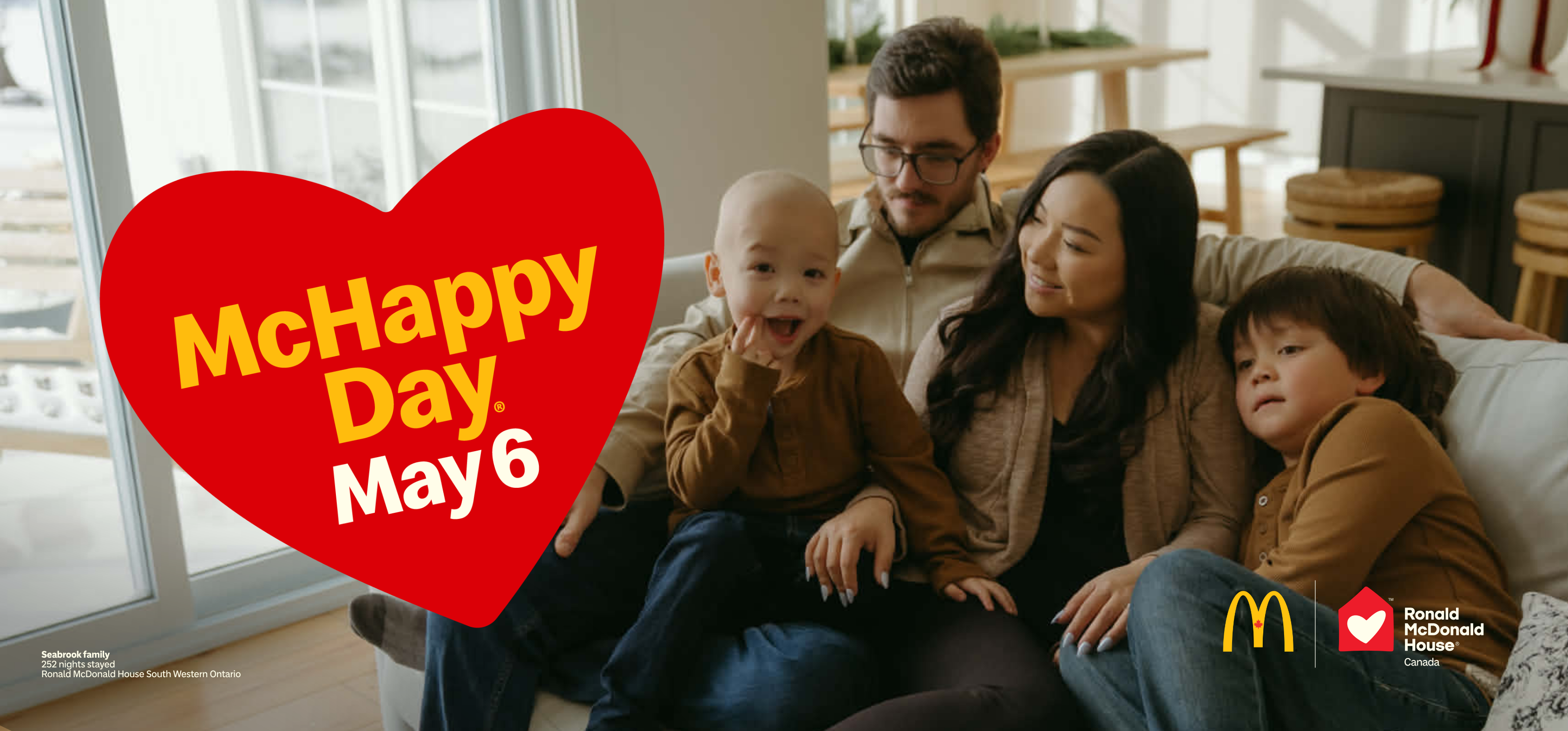 Family seated together on a couch in a bright living room with a red heart graphic reading “McHappy Day, May 6,” with McDonald’s Canada and Ronald McDonald House Canada logos