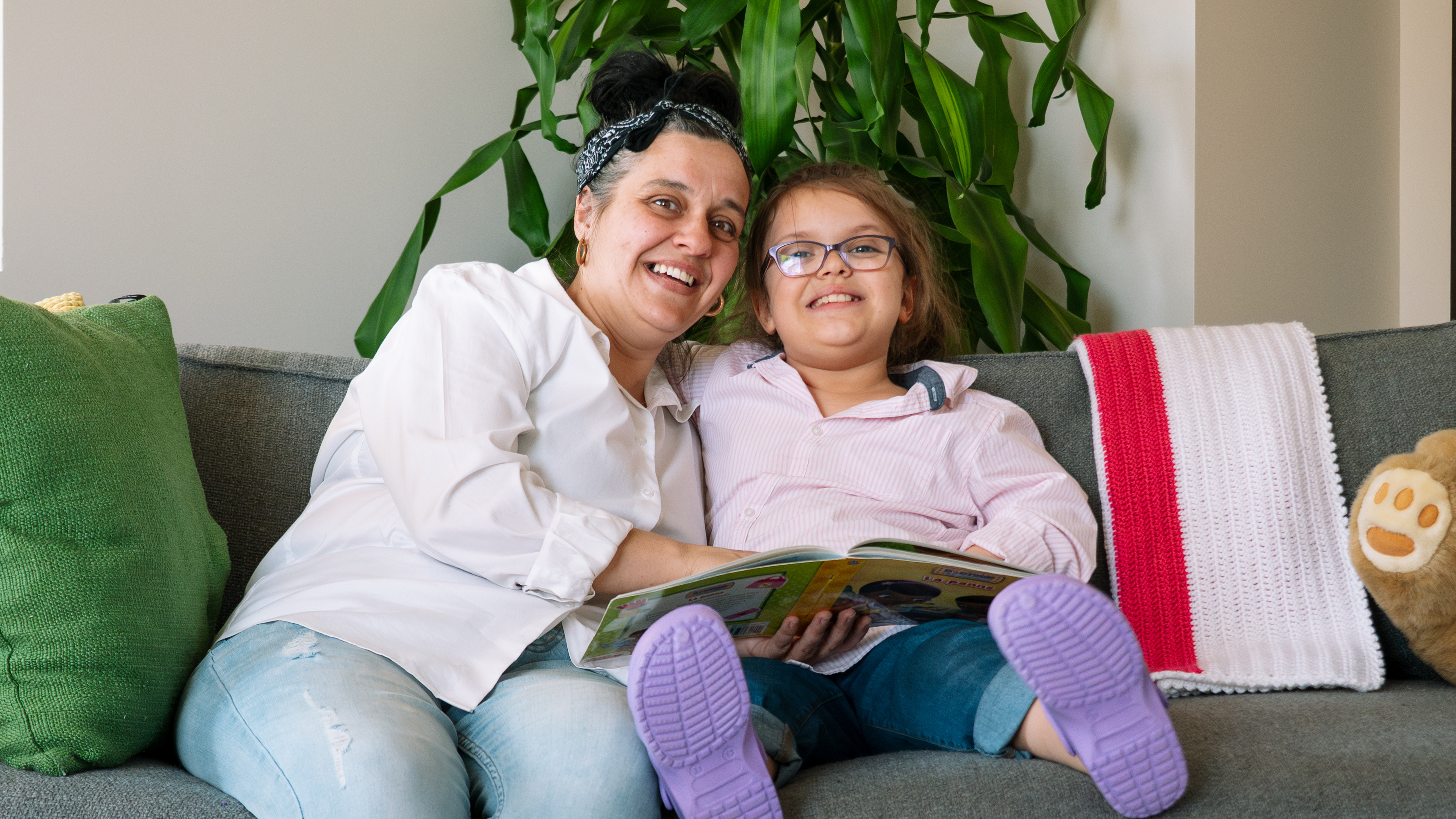 Woman and child sitting on a sofa reading