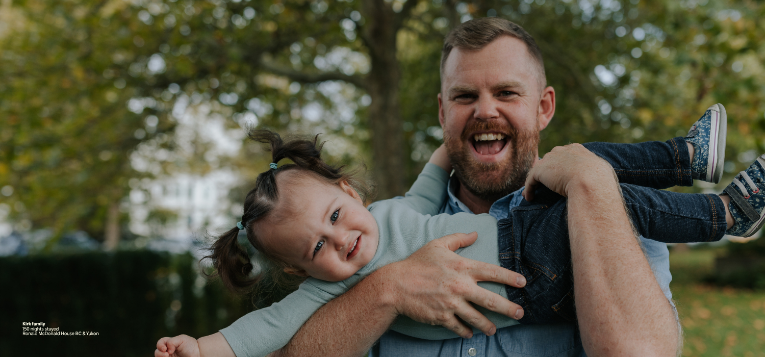 A dad holding his child outdoors